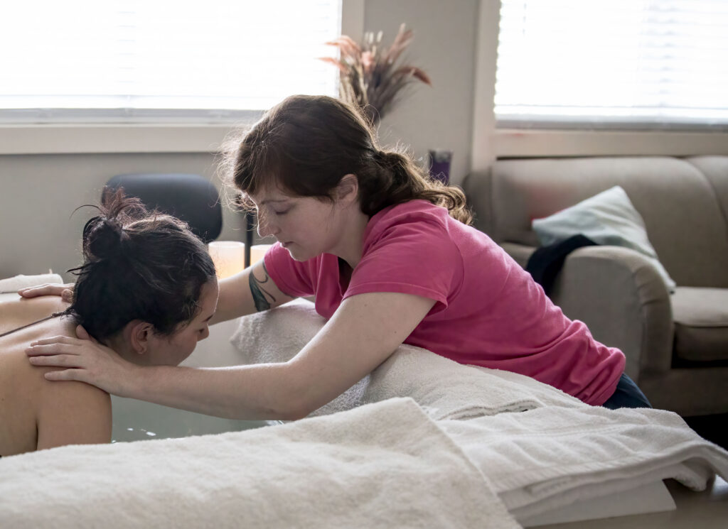 Midwife Aubrei Ackerman comforts her laboring client